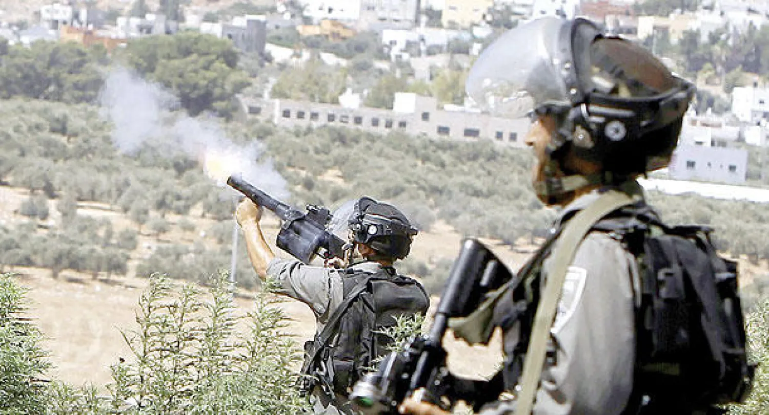 قوات حرس الحدود الإسرائيلية تطلق قنابل الغاز المسيلة للدموع لإبعاد محتجين تجمعوا بعد صلاة الجمعة للتظاهر أمس (أ.ف.ب)