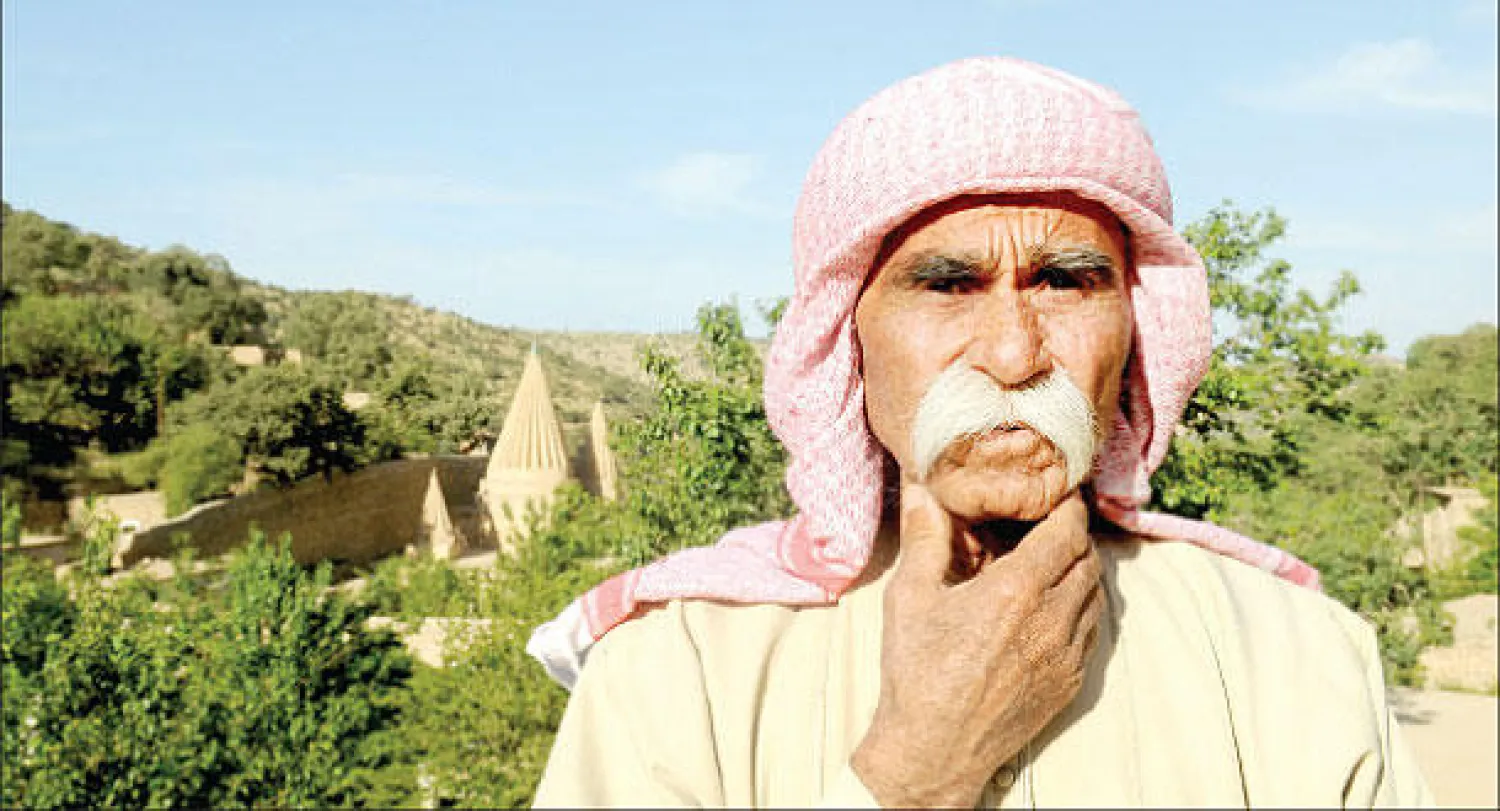 شيخ إيزيدي وخلفه معبد لالش في قضاء شيخان قرب مدينة الموصل ({الشرق الأوسط})