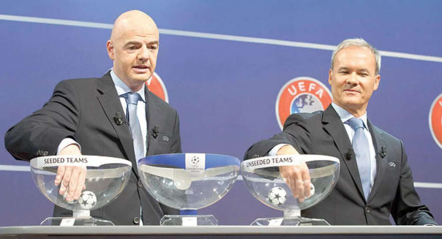 جياني إينفانتينو سكرتير عام اليويفا (يسار) ومدير الاتحاد الأوروبي للمسابقات جورجيو ماركيتي أثناء إجراء القرعة (إ.ب.أ)