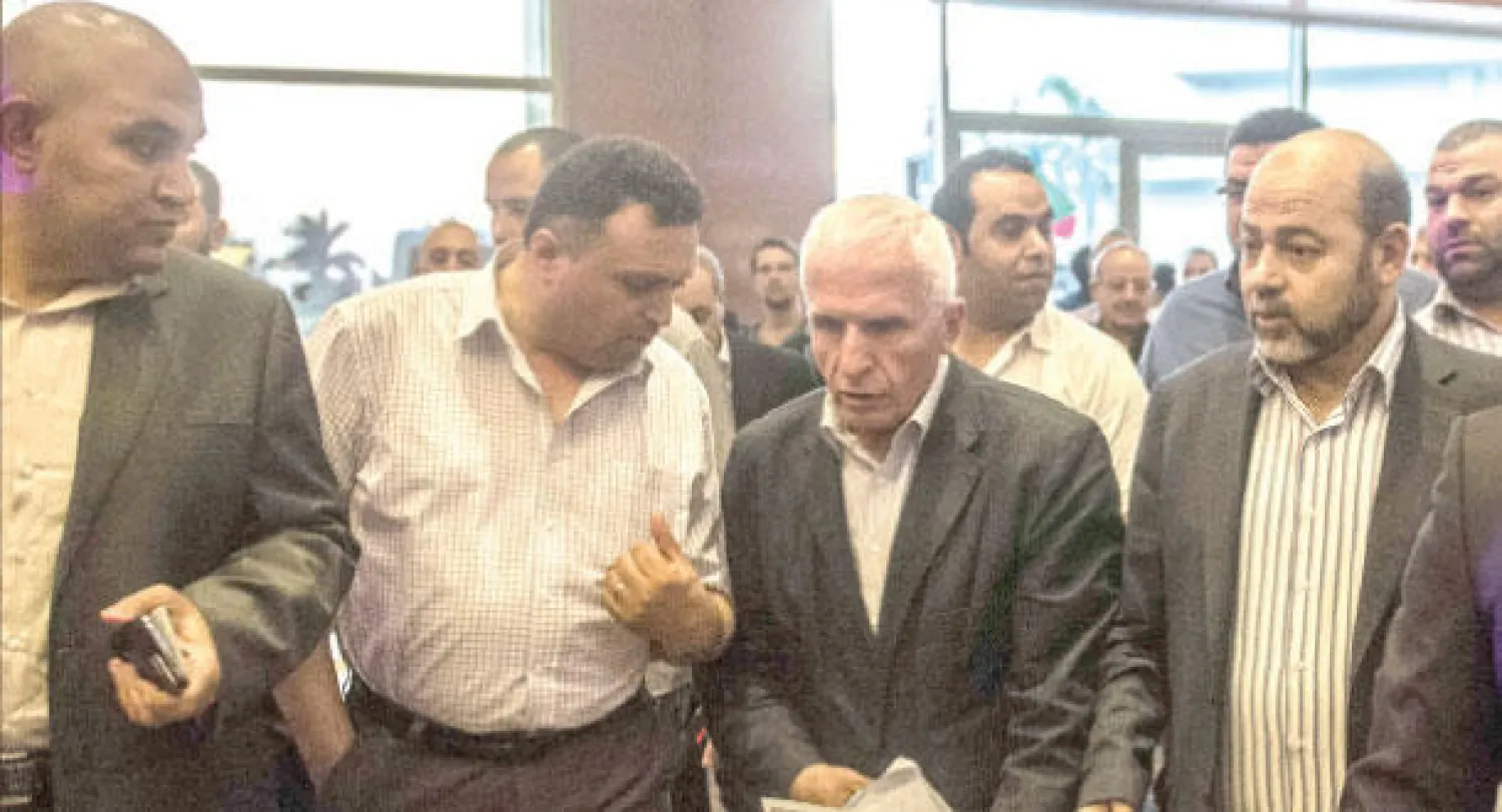 رئيس الوفد الفلسطيني عزام الأحمد (وسط) ورئيس وفد حماس موسى أبو مرزوق (يمين) لدى وصولهما إلى الفندق بعد الاجتماع مع الجانب المصري بالقاهرة أمس (أ.ف.ب)