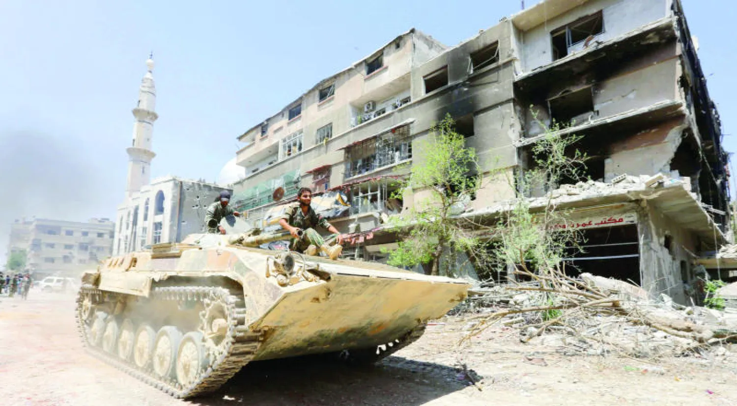 القوات الموالية للرئيس السوري بشار الأسد أثناء تقدمها نحو بلدة المليحة التي تقع على حافة المنطقة الشرقية قرب مطار دمشق بعد سيطرتهم على المنطقة من المقاتلين (أ.ف.ب)