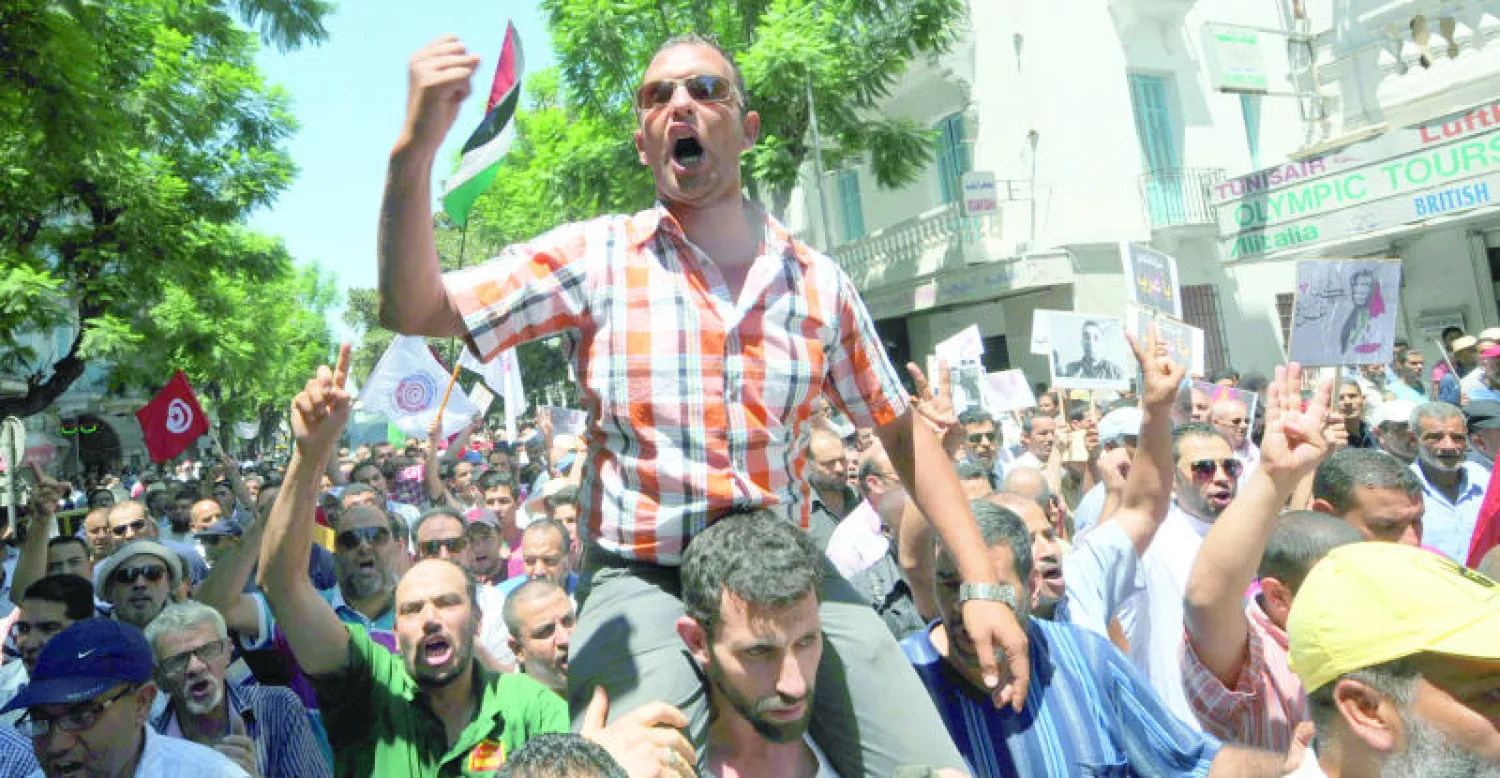 تونسي يطلق شعارات في مظاهرة احتجاجية ضد الإرهاب في العاصمة تونس (أ.ف.ب)