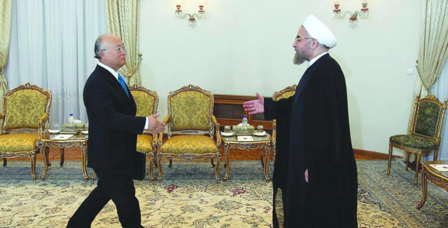 الرئيس الإيراني روحاني لدى استقباله المدير العام للوكالة الدولية للطاقة الذرية في طهران أمس (أ.ب)