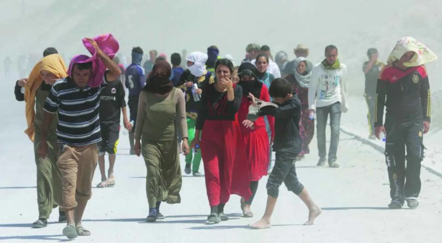 نازحون إيزيديون في مسيرة احتجاجية عند المعبر الحدودي مع تركيا في مدينة زاخو في كردستان العراق أمس (رويترز)