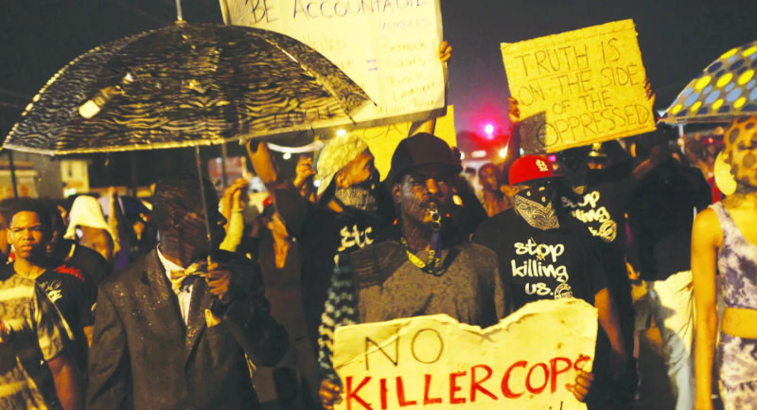 مئات المواطنين خرجوا إلى شوارع فيرغسون أمس احتجاجا على مقتل الشاب براون رغم قرار حظر التجول (أ.ف.ب)