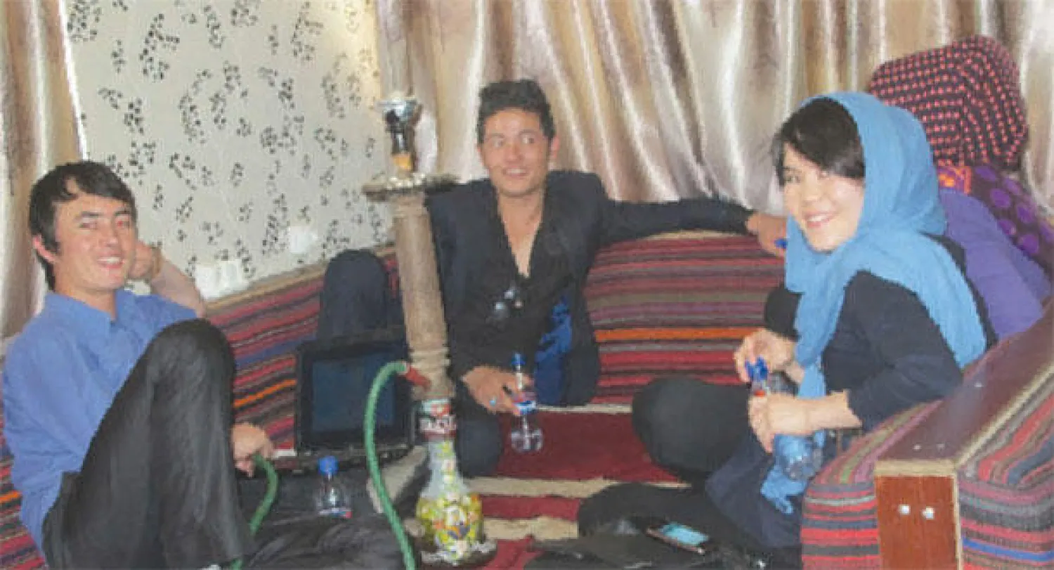 يتجمع الشباب والنساء في المقهى ويتكئون على وسائد ويشربون الشيشة ويدردشون مع بعضهم البعض (واشنطن بوست)