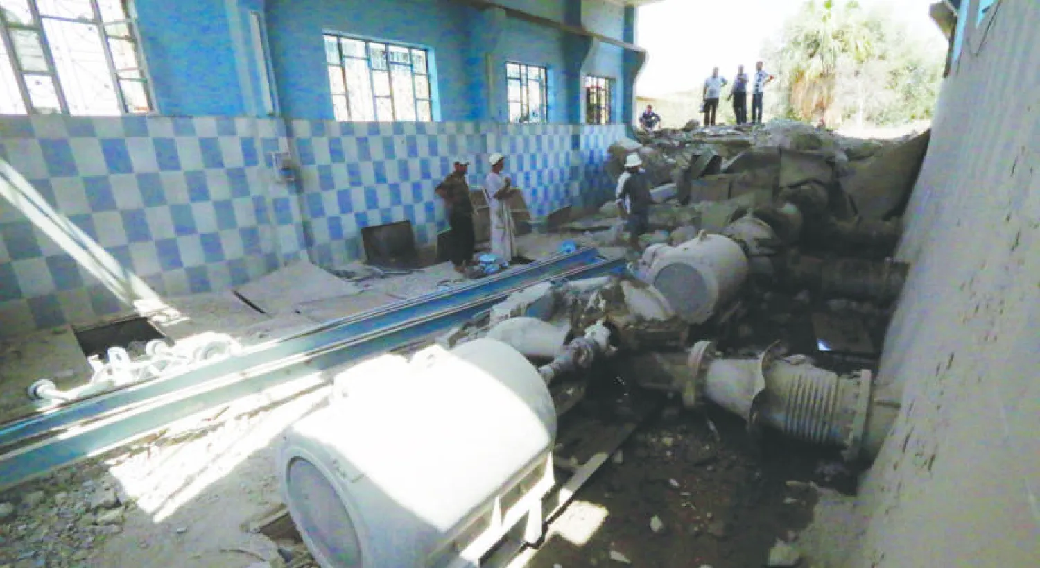 سوريون يتفقدون محطة معالجة المياه في الرقة تعرضت لأضرار بعد غارات جوية  استهدفت معاقل «داعش» في المحافظة (رويترز)