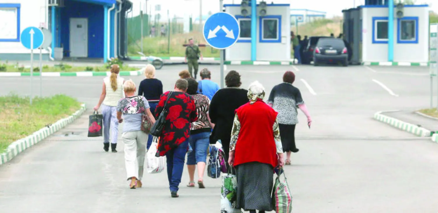 مواطنون من أوكرانيا يغادرون مدينة دونيتسك بعد اشتداد المعارك فيها أمس (رويترز)