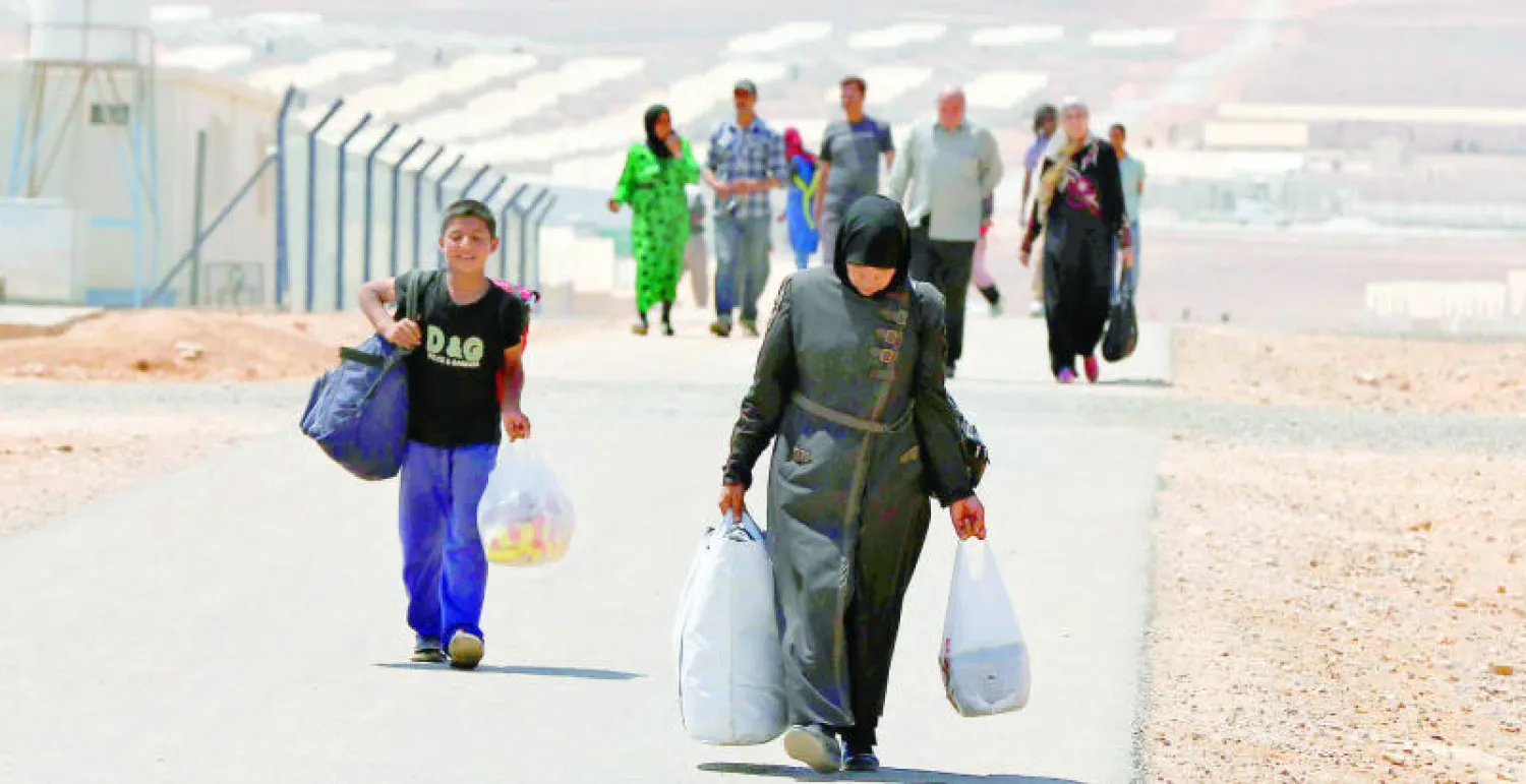لاجئون سوريون لدى وصولهم إلى مخيم أزرق شرق عمان أمس (رويترز)