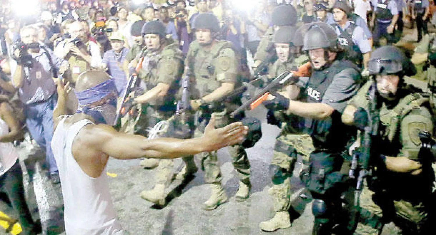 مواجهة بين عناصر الشرطة ومحتجين في فيرغسون فجر أمس (أ.ب)