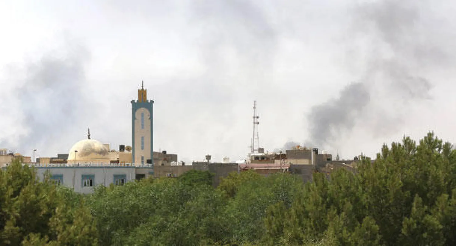 أعمدة الدخان تتصاعد في محيط مطار طرابلس أمس نتيجة المعارك الدائرة بين الميليشيات المتصارعة (أ.ف.ب)