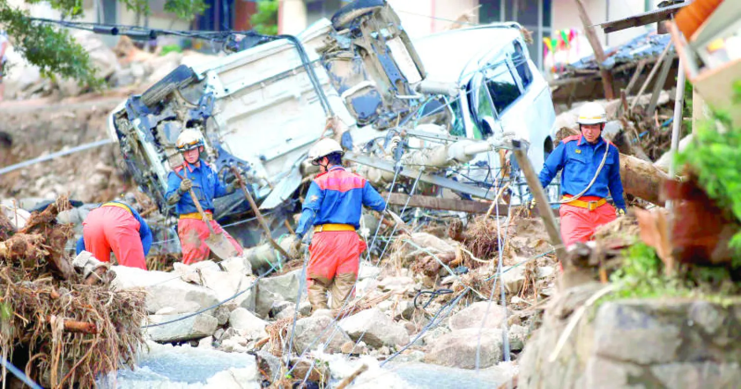 عمال إنقاذ يبحثون بين الأنقاض عن ضحايا انزلاقات التربة التي شهدتها هيروشيما أمس (رويترز)