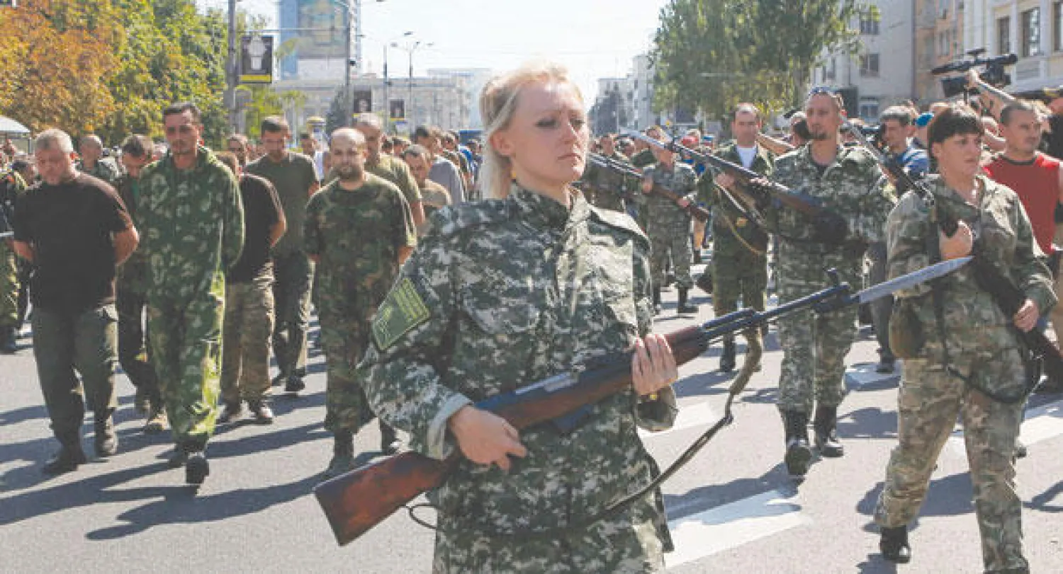 انفصاليون موالون لروسيا يرافقون عددا من الأسرى من الجيش الأوكراني في ساحة عامة بدونيتسك أمس (رويترز)