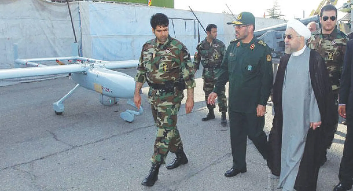 الرئيس الإيراني يعاين طائرة من دون طيار من صنع إيران خلال زيارته معرضا عسكريا في طهران أمس (إ.ب.أ)