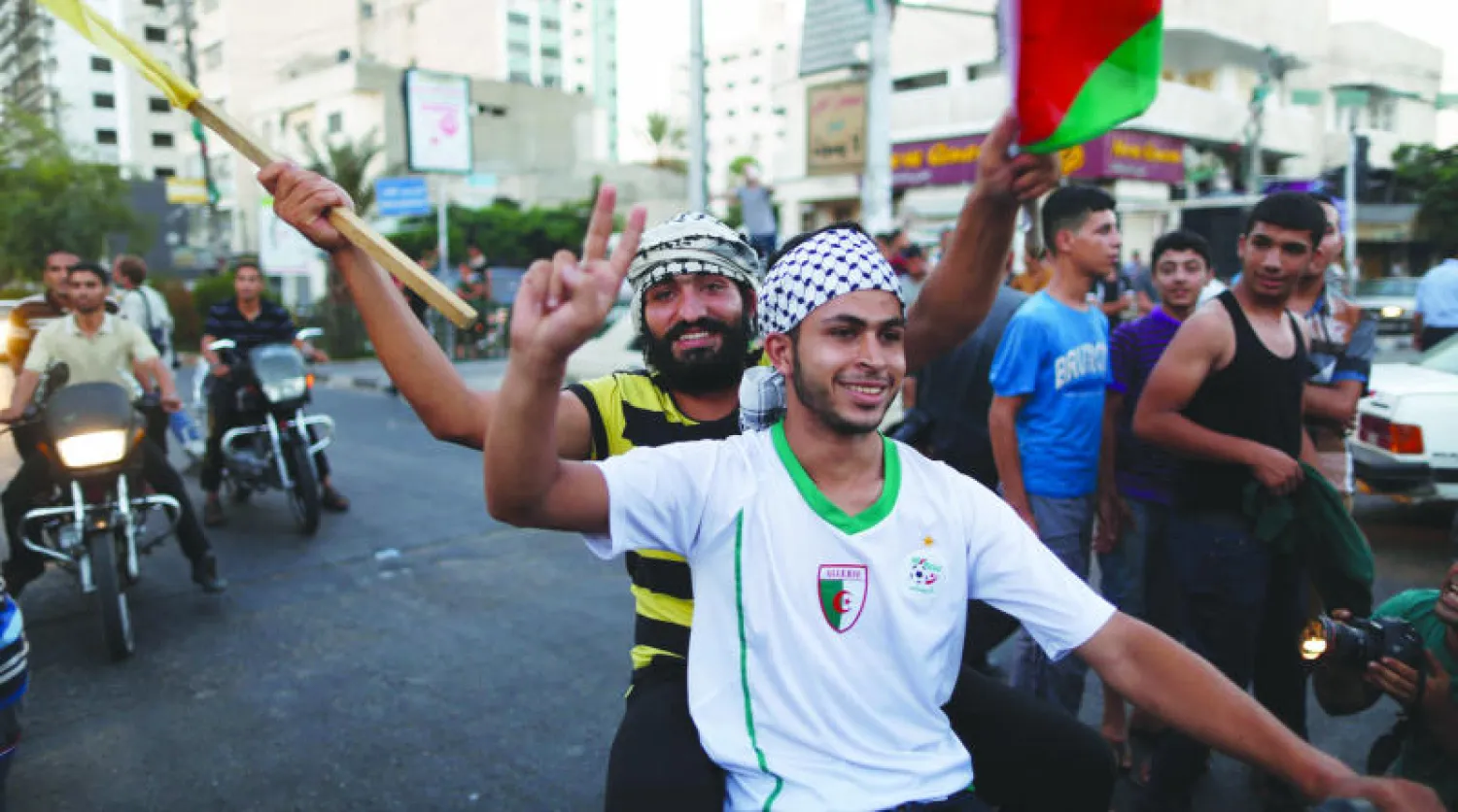 فلسطينيون يحتفلون بعد إعلان وقف إطلاق النار في قطاع غزة أمس (رويترز)