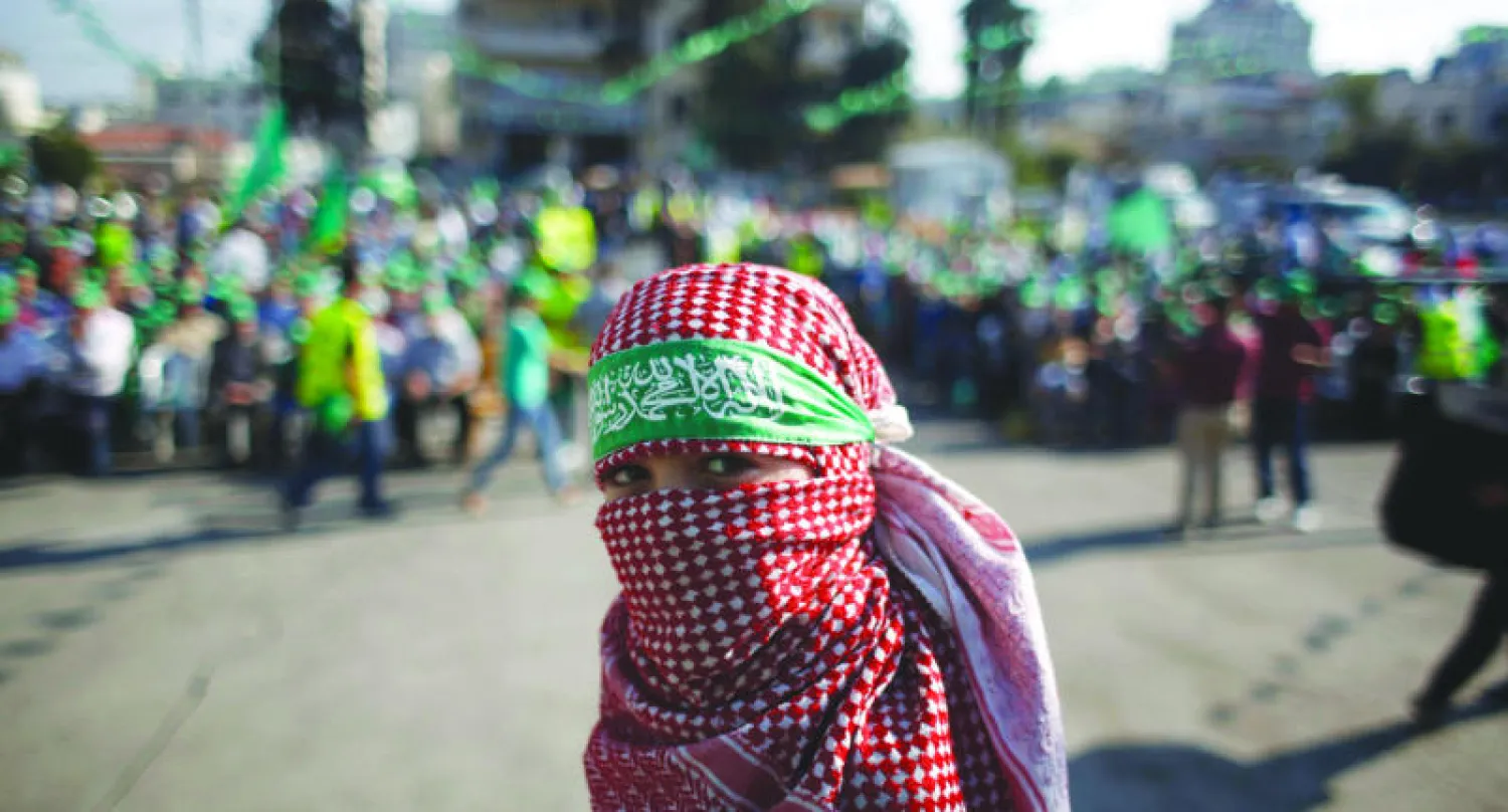 طفل فلسطيني ملثم خلال تجمع في رام الله للاحتفال بانتهاء العدوان الإسرائيلي على غزة (رويترز)