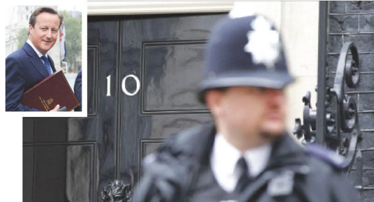 شرطي بريطاني من أسكوتلنديارد أمام مقر الحكومة البريطانية 10 داوننغ ستريت أمس (أ.ف.ب) وفي الاطار رئيس الوزراء البريطاني ديفيد كاميرون في طريقه إلى مجلس العموم أمس (إ.ب.أ)