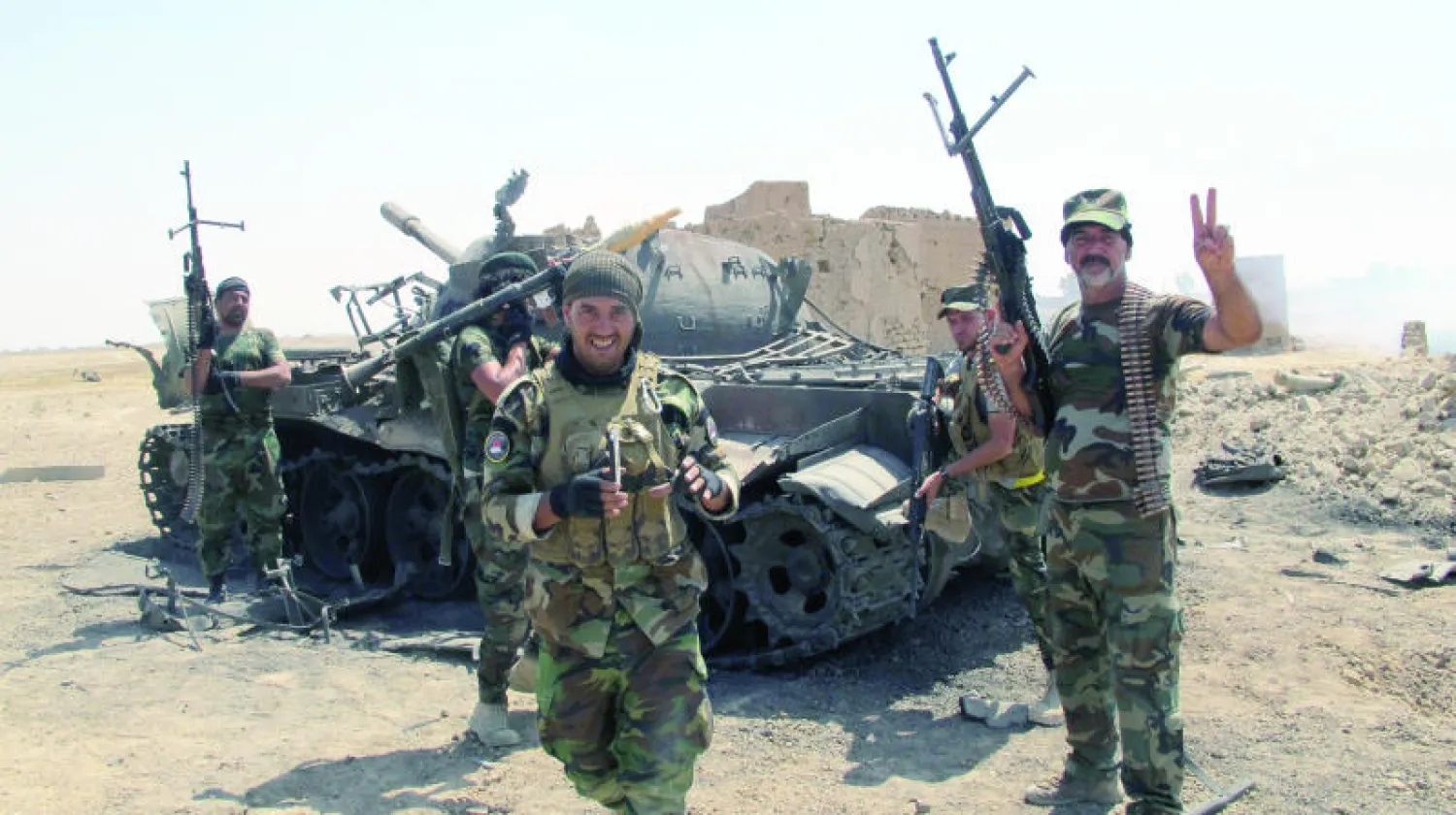 مقاتلو ميليشيا شيعية يحتفلون بانتصارهم في آمرلي أمس (رويترز)