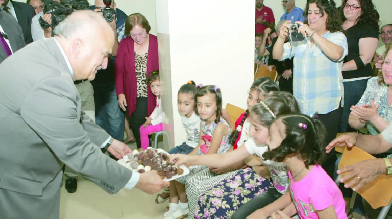 الأمير الحسن بن طلال يقدم الحلوى لأطفال عراقيين مسيحيين في عمان أمس («الشرق الأوسط»)