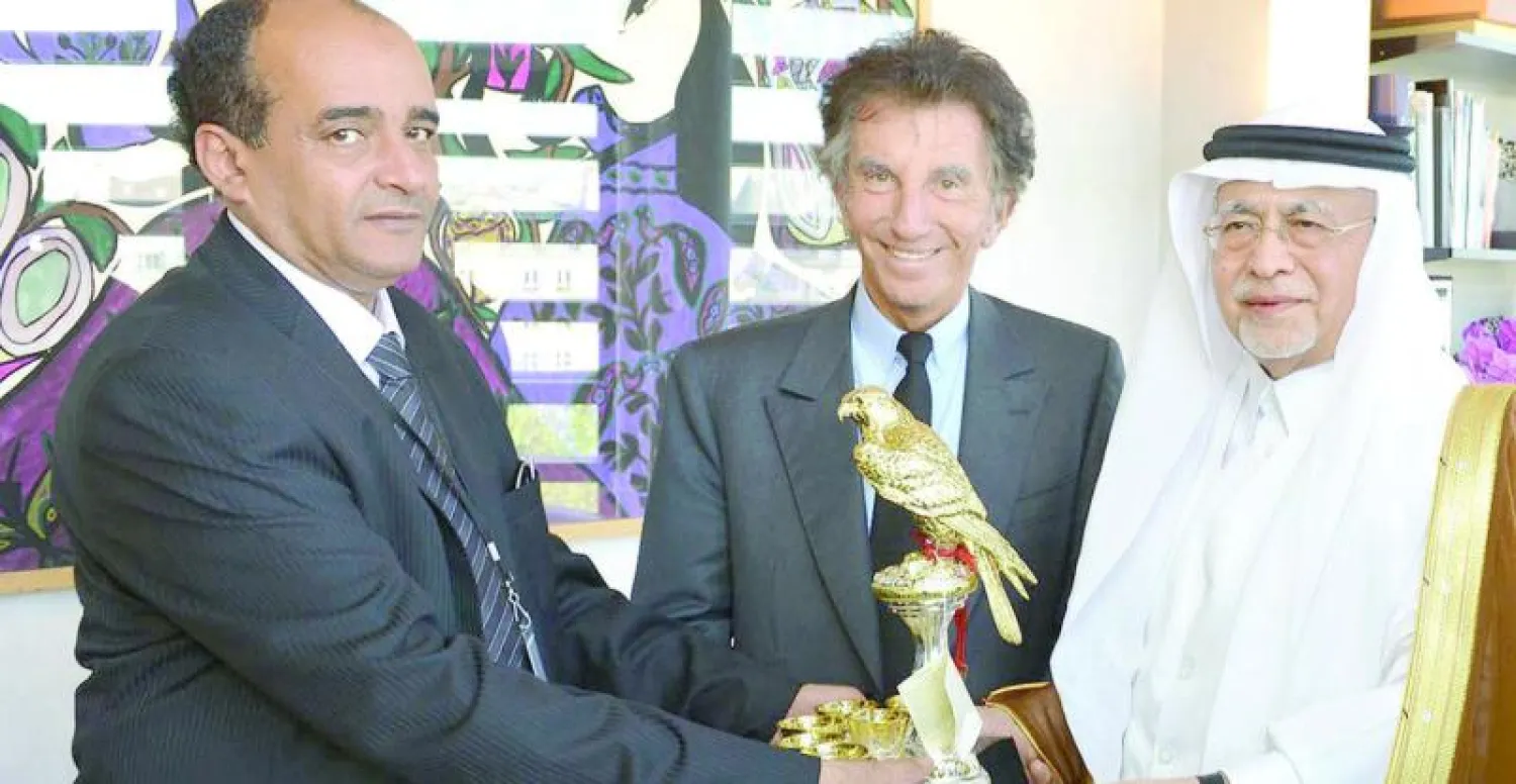 وزير الثقافة والإعلام السعودي يتسلم هدية تذكارية لدى زيارته معهد العالم العربي في باريس أمس (واس)