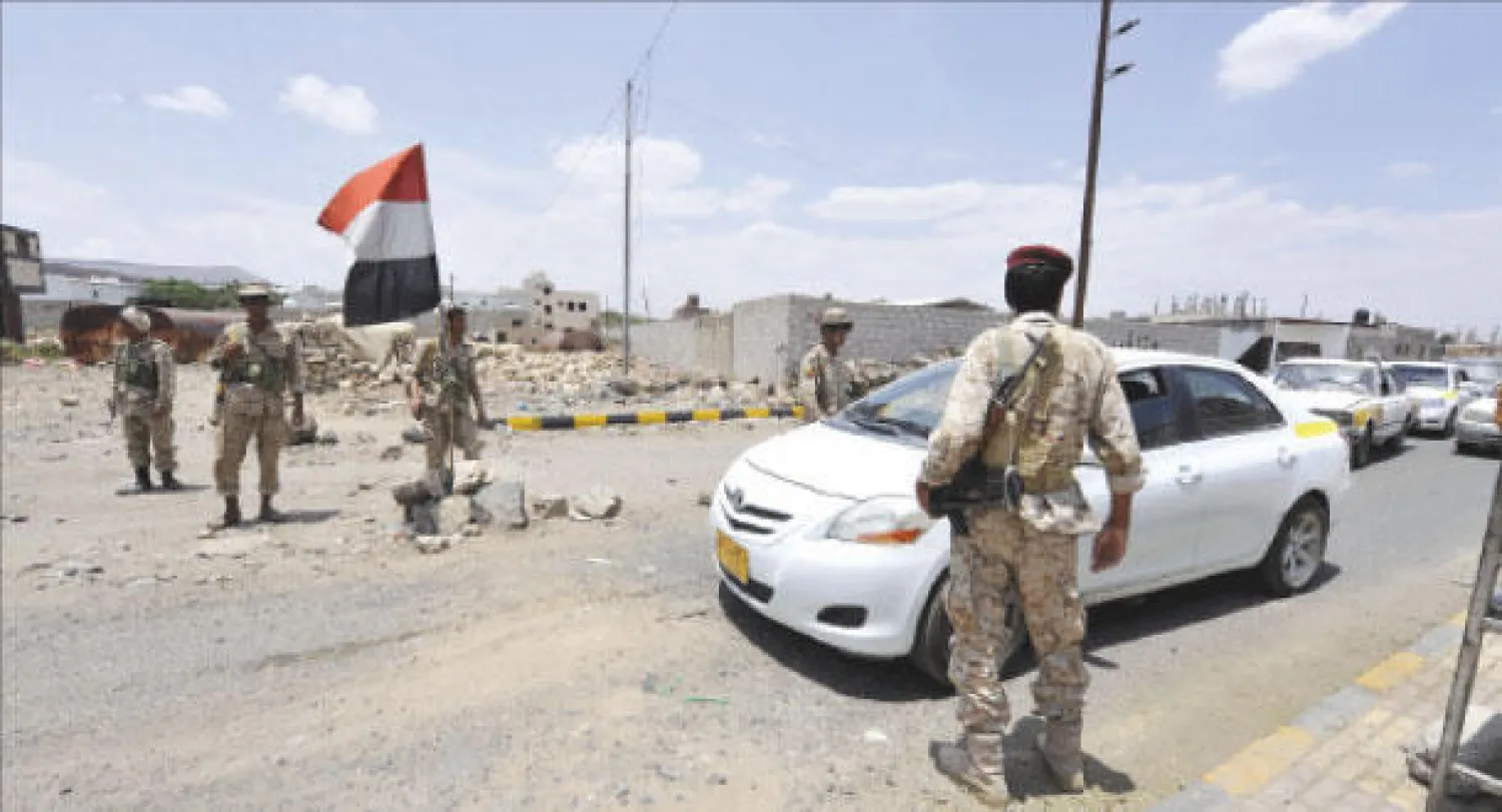 جنود يمنيون يفحصون سيارة عند إحدى نقاط التفتيش في صنعاء أمس (إ.ب.أ)