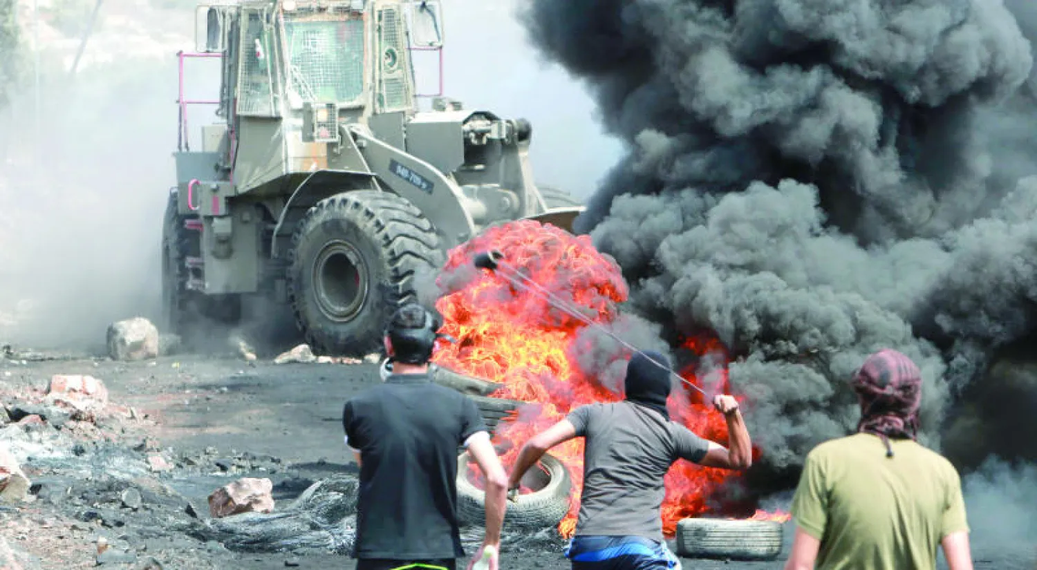 متظاهرون فلسطينيون يقذفون حجارة بمقاليعهم على آلية إسرائيلية في مستوطنة قدوميم قرب نابلس بالضفة الغربية (رويترز)