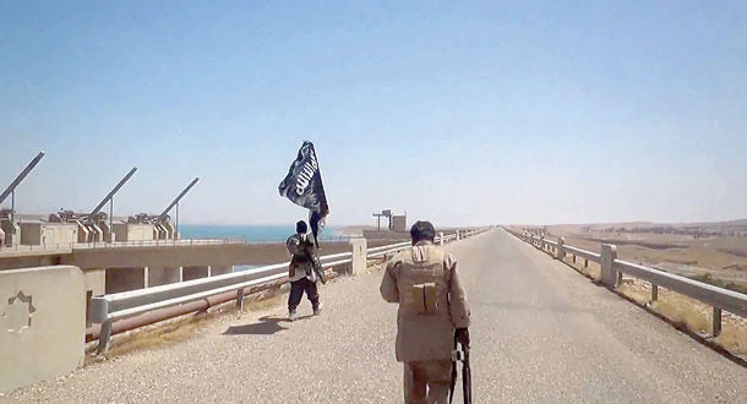 ارشيفية لصورة نشرت على الموقع الإعلامي لتنظيم «داعش» تظهر اثنين من مسلحيه في سد الموصل (أ.ف.ب)