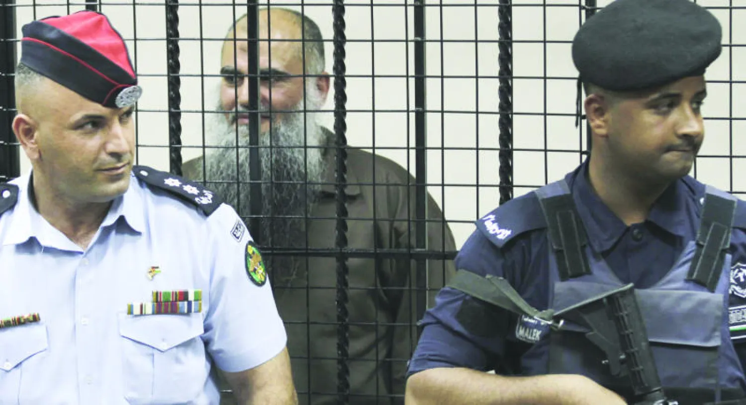 منظر التيار السلفي عمر محمود محمد عثمان الملقب بـ«أبو قتادة» خلف القضبان أمام محكمة أمن الدولة الأردنية في العاصمة عمان أمس (أ.ف.ب)