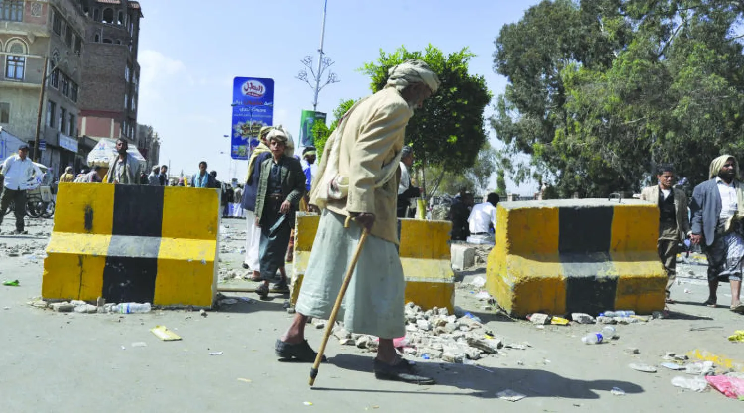 مسن يمني يمر أمام متحجين من الحوثيين في صنعاء أمس (إ.ب.أ)