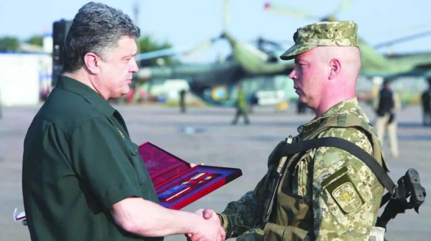 الرئيس الأوكراني لدى لقائه بقائد عسكري في مطار ماريوبول حيث سلم عددا من القادة أوسمة أمس (أ.ف.ب)