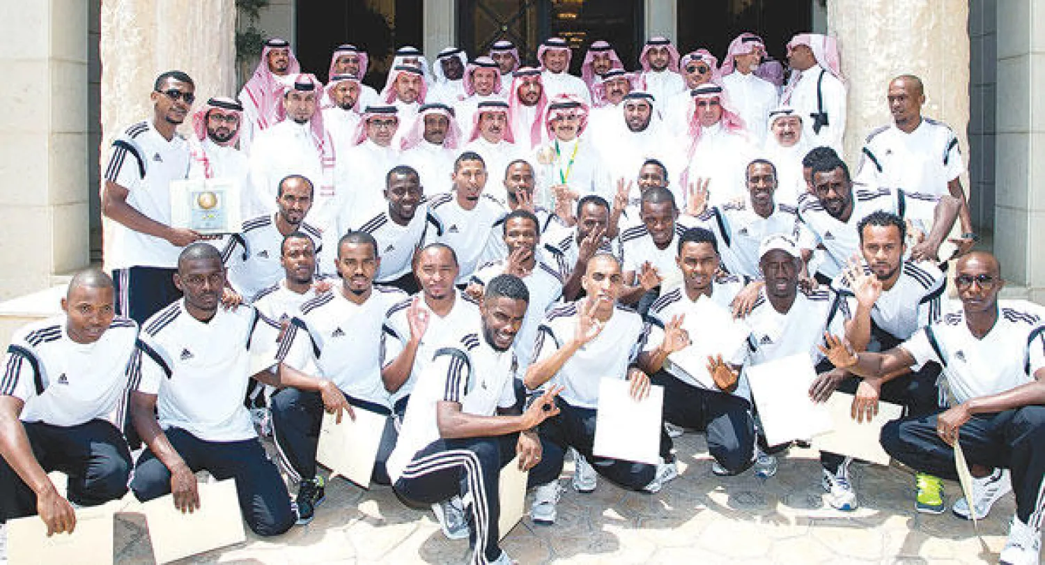 الأمير الوليد بن طلال في صورة جماعية أثناء استقباله أبطال العالم