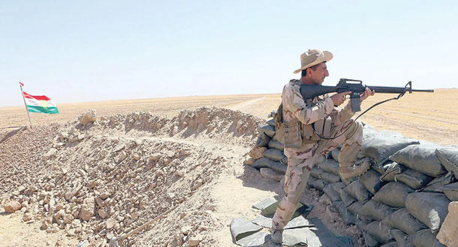 عنصر من البيشمركة يصوب بندقيته  على هدف قرب مخمور جنوب غربي أربيل (إ.ب.أ)