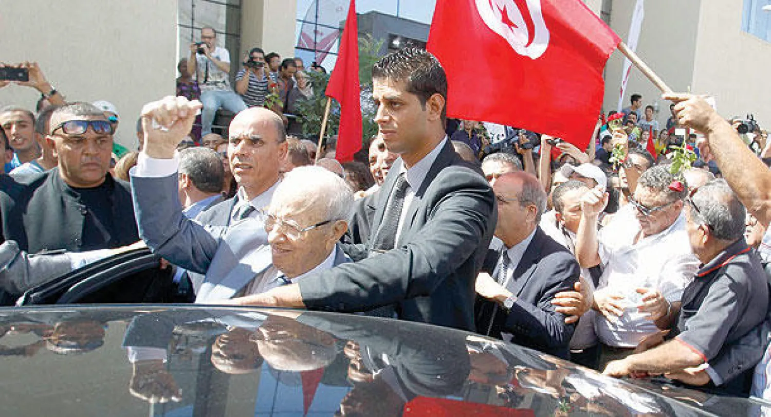 الباجي قائد السبسي زعيم نداء تونس يحيي أنصاره عقب تقديمه ترشحه لرئاسة الجمهورية أمس (رويترز)