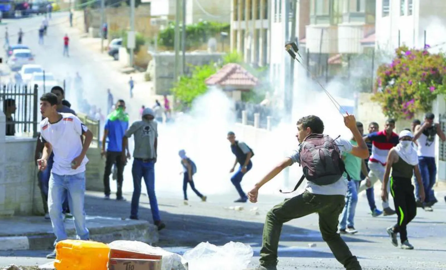 شبان فلسطينيون يرمون قوات الاحتلال الإسرائيلي بالحجارة بعد تشييع جنازة الشاب عيسى القطري في رام الله أمس (أ.ف.ب)