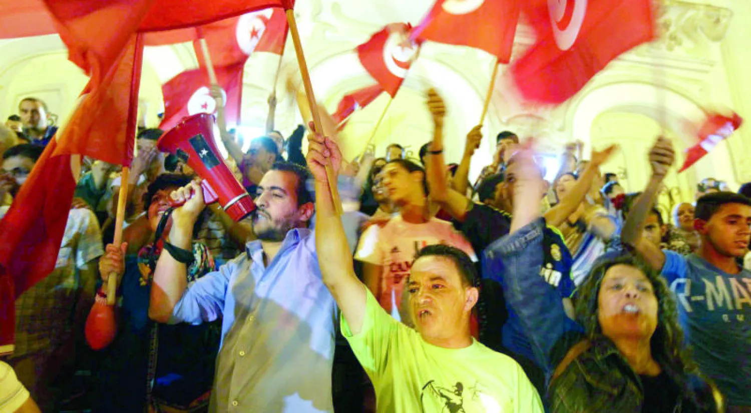 تونسيون يحملون علم  بلادهم خلال مظاهرة سابقة نظمت في أحياء تونس العاصمة تنديدا بالإرهاب (رويترز)