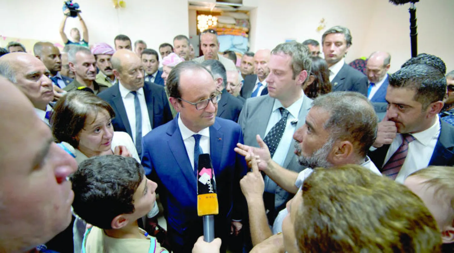 الرئيس الفرنسي فرنسوا هولاند لدى زيارته معسكرا للاجئين بالقرب من مدينة اربيل في اقليم كردستان (أ.ب)