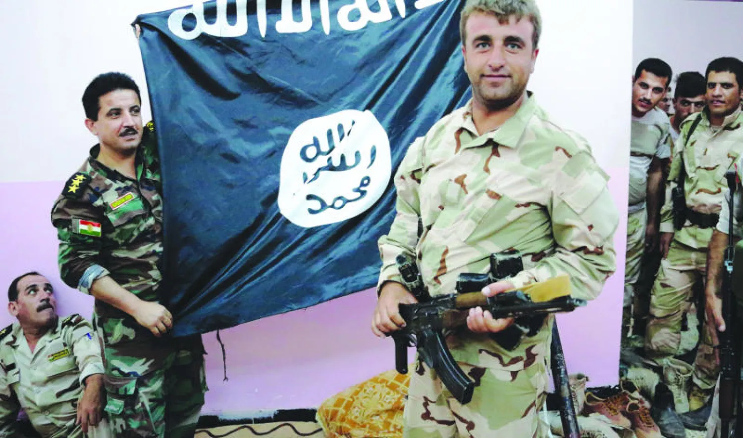 عناصر في البيشمركة الكردية يقفون لالتقاط صورة بعد استيلائهم أول من أمس على موقع كان خاضعا لسيطرة «داعش» 30 كيلومترا إلى الشمال من كركوك (أ.ف.ب)