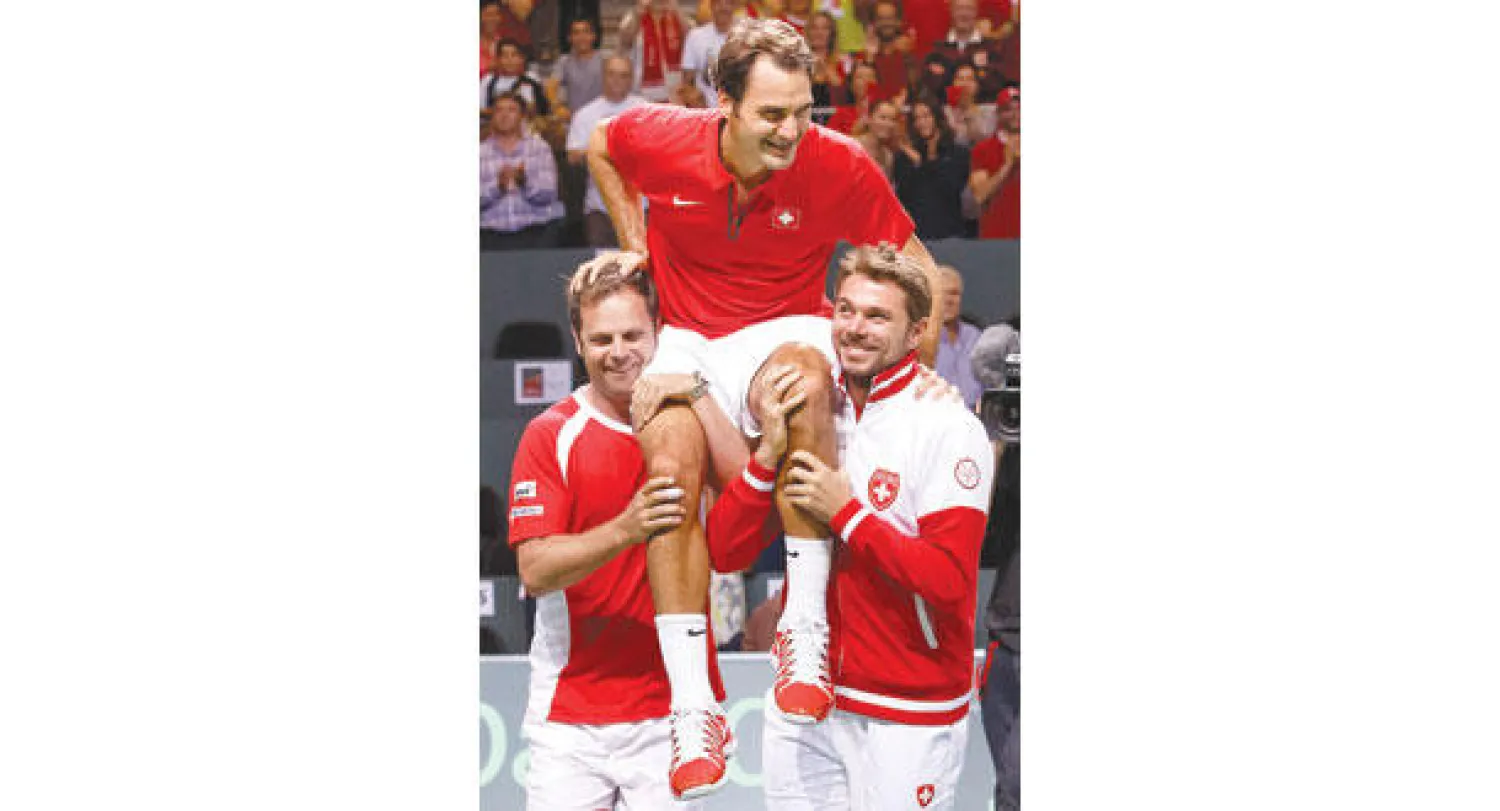 لاعبو سويسرا يحملون فيدرر بعد أن قاد الفريق لنهائي كأس ديفيز (أ.ب)