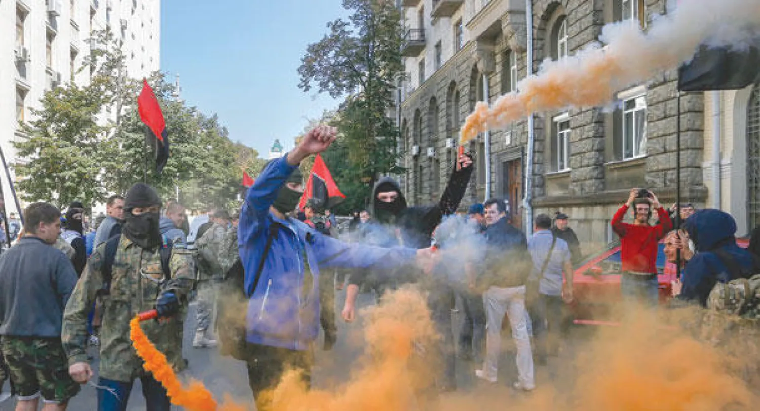 أنصار للأحزاب اليمينية المتطرفة الأوكرانية لدى تظاهرهم قرب مقر الرئاسة في كييف أمس احتجاجا على عزم الرئيس بوروشينكو العفو عن المقاتلين الانفصاليين في مناطق الشرق (إ.ب.أ)