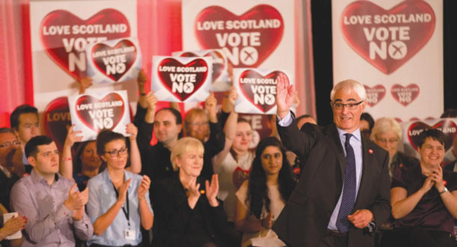 وزير الخزانة البريطاني السابق أليستر دارلينغ يشير بيده في ختام كلمة له أمام حشد من الرافضين للانفصال في غلاسكو أمس (أ.ب)