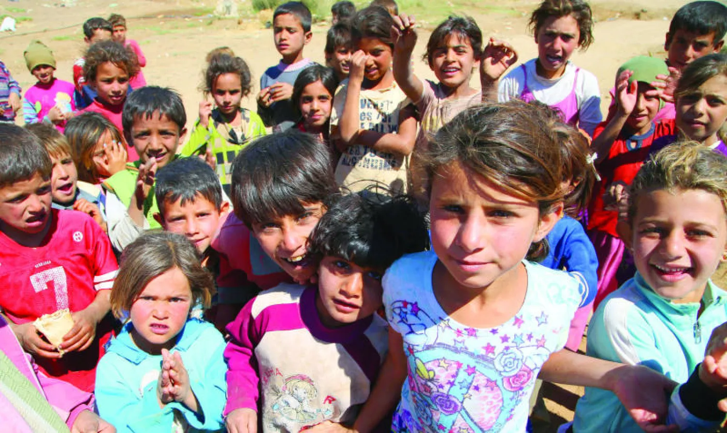 أطفال سوريون متجمعون أثناء زيارة مبعوث الأمم المتحدة لمخيم للاجئين في بعلبك اللبنانية الثلاثاء (أ.ب)