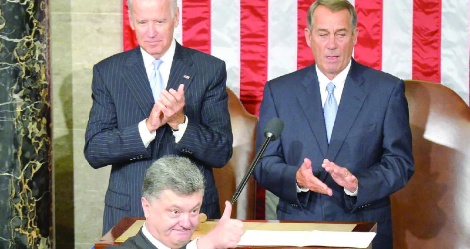 بوروشينكو أثناء إلقاء كلمته أمام الكونغرس وبدا خلفه رئيس مجلس النواب جون بينر (يمين) ونائب الرئيس الأميركي جو بايدن في واشنطن أمس (أ.ف.ب)