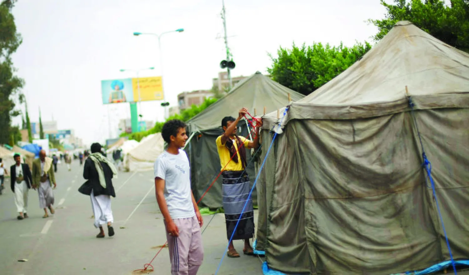 متظاهرون حوثيون ينصبون خياما في الشارع الرئيسي المؤدي إلى مطار صنعاء أمس (أ.ب)