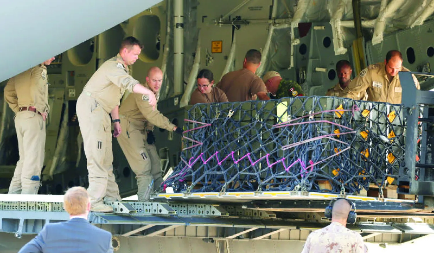 عناصر من القوة الجوية الكندية يحملون ذخائر أسلحة مقدمة من الجيش التشيكي لحكومة إقليم كردستان العراق أمس (أ.ب)