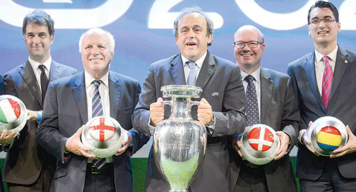 بلاتيني رئيس اليويفا يتوسط ممثلي الدول التي ستستضيف التصفيات (أ.ب)