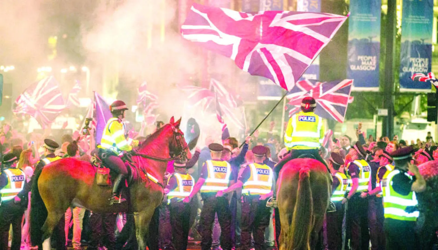 ضباط شرطة يحرسون مظاهرة لاسكوتلنديين من أنصار الوحدة في مدينة غلاسكو الليلة قبل الماضية (إ.ب.أ)