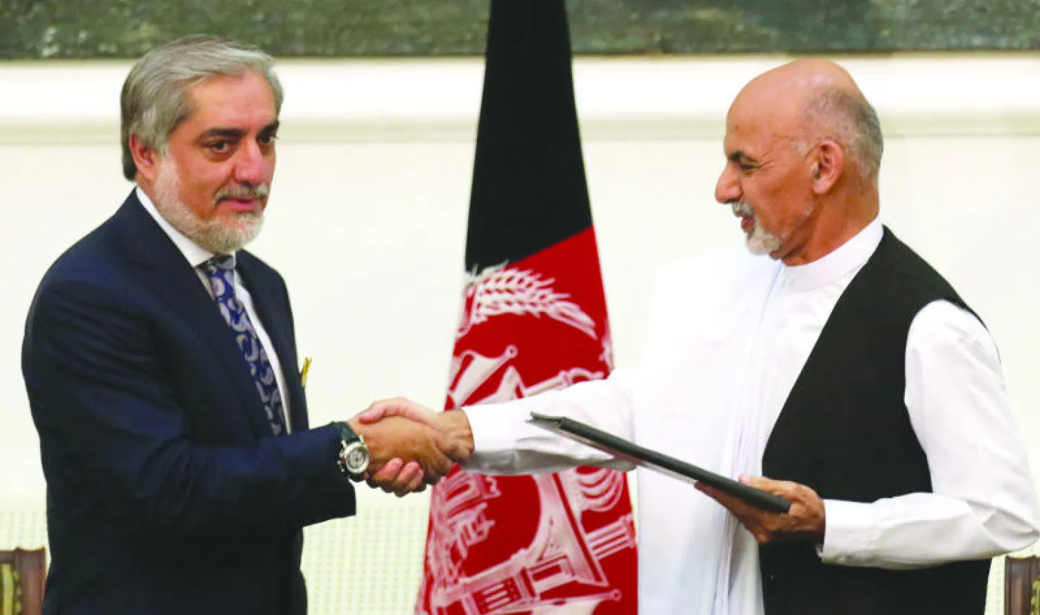 أشرف عبد الغني وعبد الله عبد الله عقب التوقيع على اتفاق لاقتسام السلطة في حكومة وحدة في العاصمة كابل أمس (إ.ب.أ)