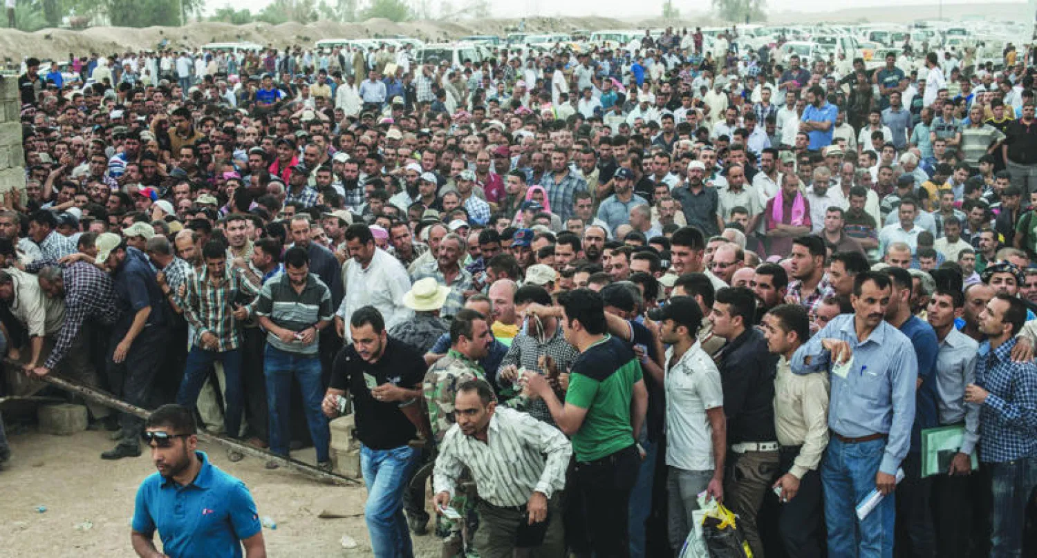 عراقيون ينتظرون عبور معبر «مكتب خالد» على خط التماس بين قوات البيشمركة ومسلحي «داعش» إلى الغرب من كركوك (نيويورك تايمز)