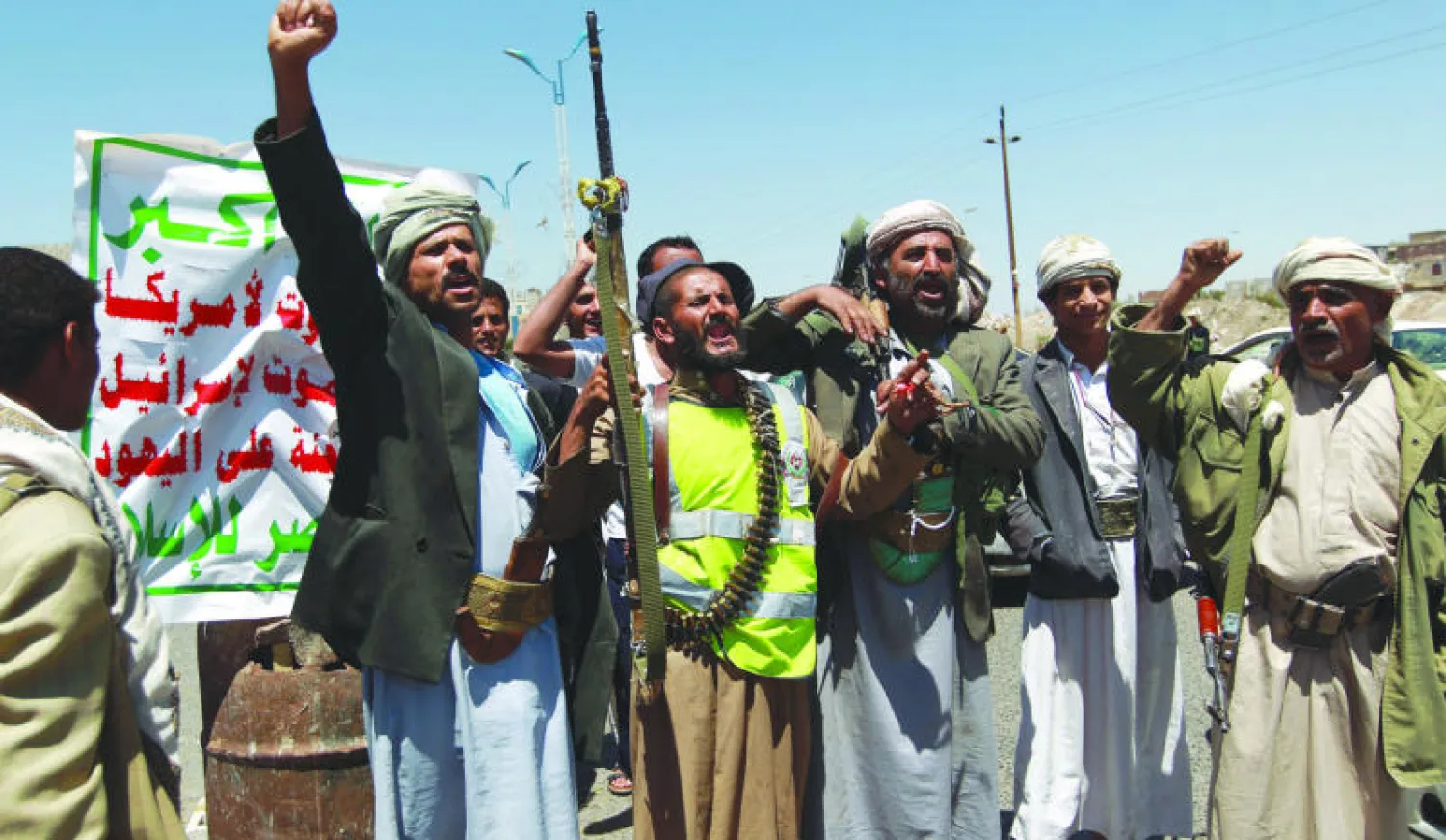مسلحون حوثيون يهتفون ضد الحكومة اليمنية قرب نقطة تفتيش نصبوها بعد أن حاصروا المنطقة الشمالية من العاصمة صنعاء أمس (أ.ف.ب)