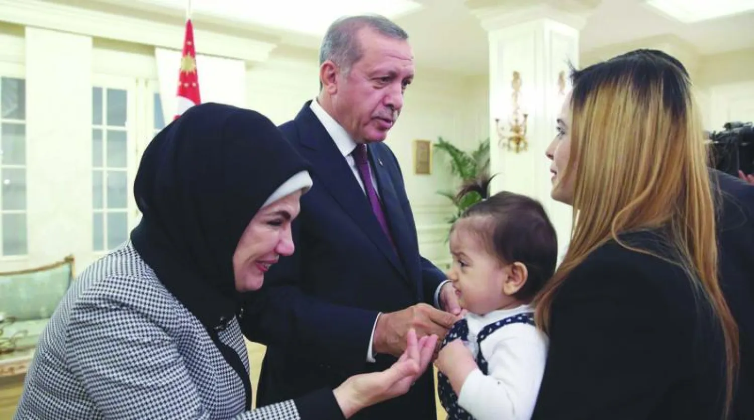 الرئيس التركي رجب طيب إردوغان وزوجته أمينة لدى استقبالهما أمس بعض الرهائن الأتراك السابقين في الموصل الذين أخلى «داعش» سبيلهم (أ.ف.ب)